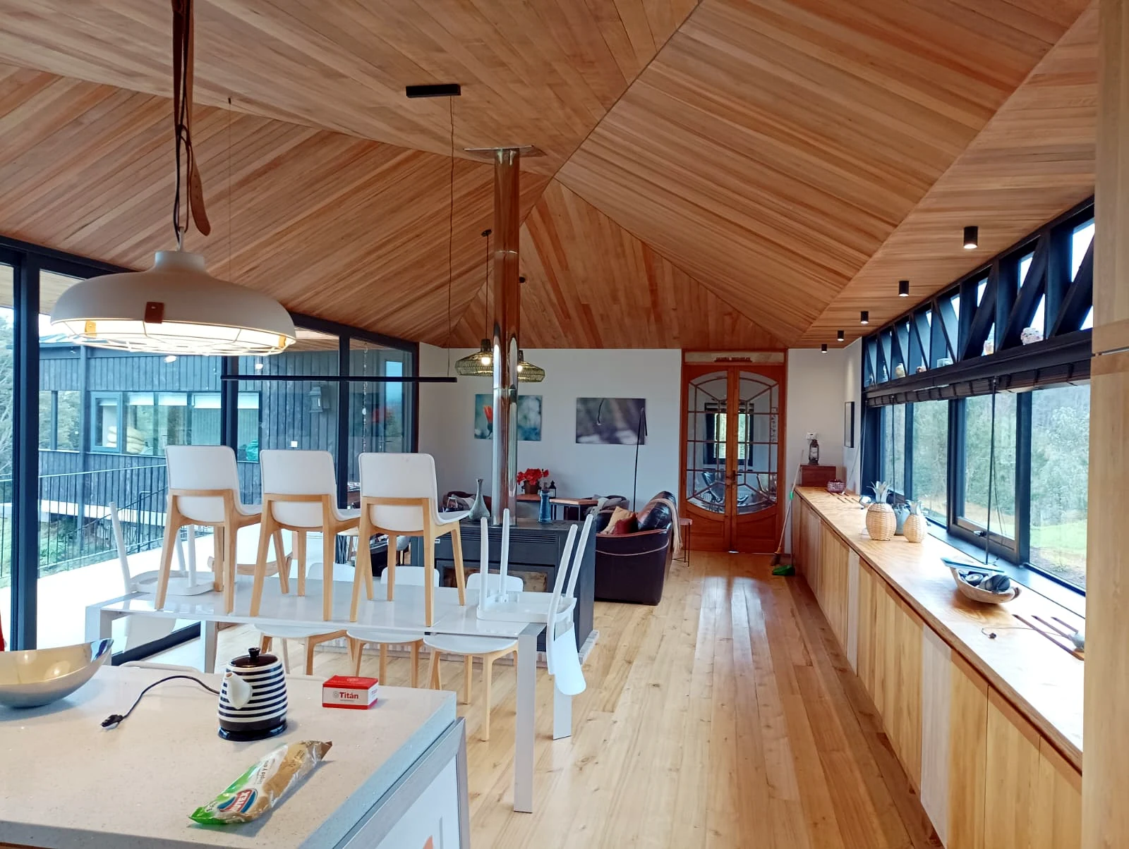 Interior con cubierta inclinada de madera durante etapa final de terminaciones