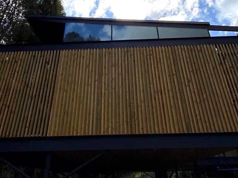 Detalle frontal de celosía vertical de madera en fachada