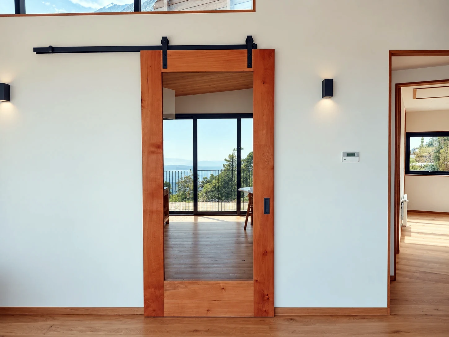 Detalle interior de puerta corredera de madera con paño vidriado y herraje superior negro