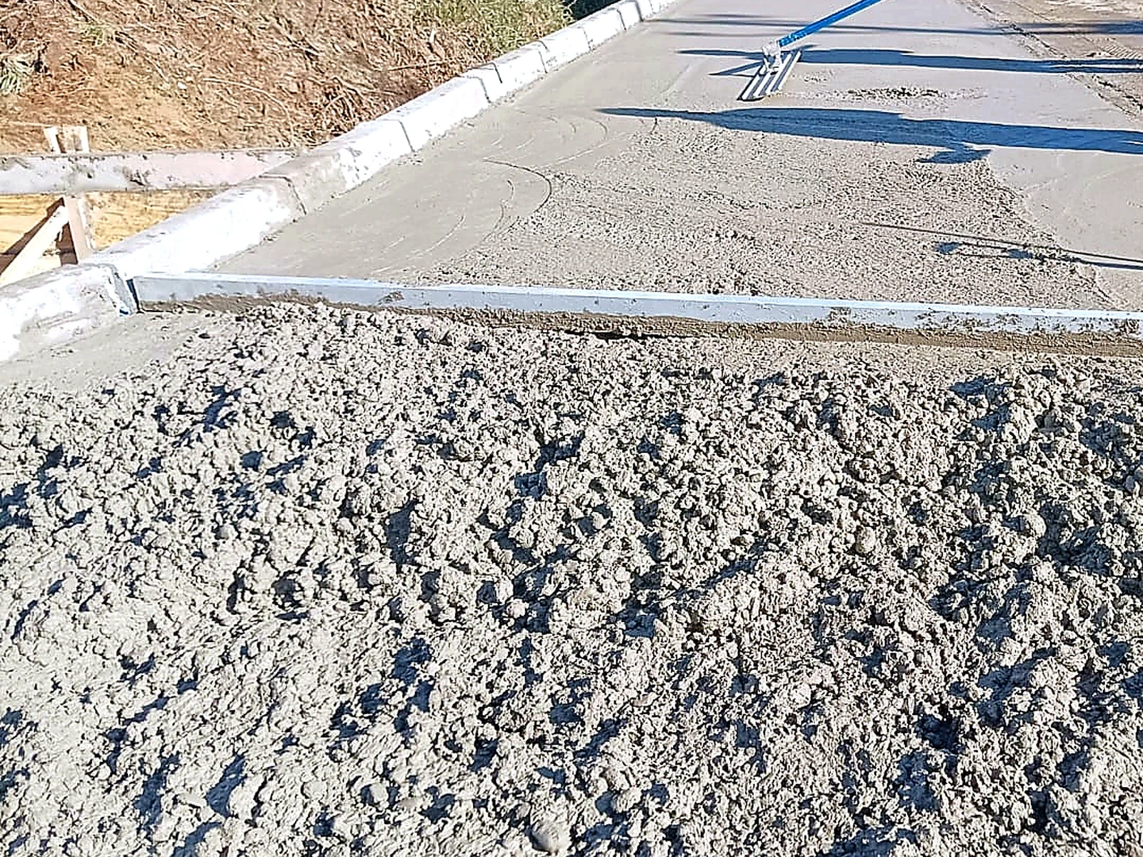 Proceso de hormigonado y nivelación de acceso exterior con superficie en ejecución